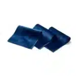 Trois carrés d'échantillons de tissu en velours bleu canard pliés et disposés en cascade sur fond blanc.