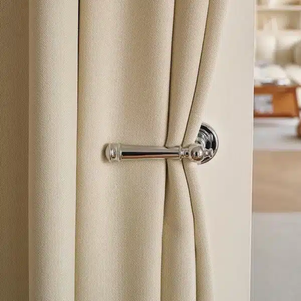 Détail du rideau isolant thermique et phonique beige près d’une poignée de porte, montrant la texture et l’épaisseur du tissu.