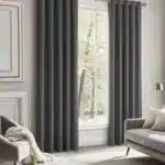 Rideaux thermiques épais gris anthracite installés dans un salon lumineux et élégant avec mobilier contemporain.
