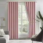 Rideaux thermiques épais roses habillant une grande fenêtre dans un salon raffiné avec mobilier design.
